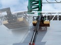 Construction worker at construction site using lifting boom machinery Royalty Free Stock Photo