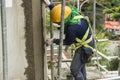 A construction worker smoothing out a still wet concrete wall with a straight wooden plank. Royalty Free Stock Photo