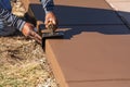 Construction Worker Smoothing Wet Cement With Curb Tool