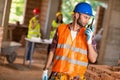 Construction worker talking on walkie talkie at site