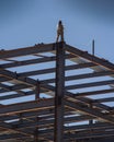 A construction worker on the the top of an iron beam framing of a commercial building under construction Royalty Free Stock Photo