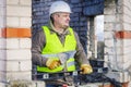 Construction worker with trowel and level near wall Royalty Free Stock Photo