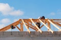 Construction worker, tying trusses together, for greater structural support