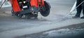 Construction worker using an asphalt saw cutting machine to excavate street