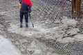 Construction worker using concrete vibrator for compacting concrete