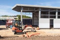 Construction worker using a digger on building site with idustrial units