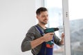 Construction worker using drill while installing window Royalty Free Stock Photo