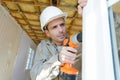 Construction worker using drill to install replacement window Royalty Free Stock Photo