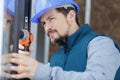 Construction worker using drill to install window