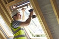 Construction Worker Using Drill To Install Window