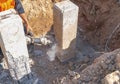 Construction worker using electric jackhammer drill to break reinforced concrete pillar