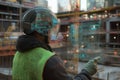 Construction Worker Using Futuristic HUD at Busy Construction Site