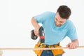 Construction worker using hand drill on wooden plank Royalty Free Stock Photo