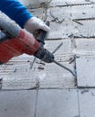 Construction worker using a handheld demolition hammer and wall breaker to chip away and remove old floor tiles during renovation Royalty Free Stock Photo