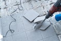 Construction worker using a handheld demolition hammer and wall breaker to chip away and remove old floor tiles during renovation Royalty Free Stock Photo