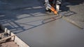 Construction worker using long triangle trowel to plastering cement on the floor in construction site Royalty Free Stock Photo