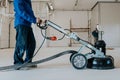 Construction worker using machine polishing surface floor smoothing and finishing hardener or epoxy concrete in the factory Royalty Free Stock Photo