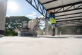 Construction worker using machine polishing surface floor smoothing and finishing hardener or epoxy concrete at construction site Royalty Free Stock Photo