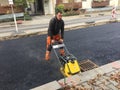 Construction worker using a plate compactor