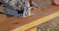 Construction worker using a Skil Saw on weatherproof wood cutting an angle with sawdust blowing
