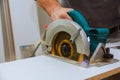 Construction worker using slider compound mitre saw or circular saw for cutting massive wood board. Royalty Free Stock Photo