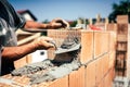 Construction worker using spatula and trowel for building walls with bricks and mortar Royalty Free Stock Photo