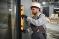Construction worker using spirit level while installing modular house door Royalty Free Stock Photo