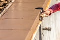 Construction Worker Using Stainless Steel Edger On Wet Cement Forming Coping Around New Pool Royalty Free Stock Photo