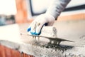 Construction worker using steel trowel for plastering