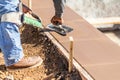 Construction Worker Using Trowel On Wet Cement Forming Coping Around New Pool Royalty Free Stock Photo