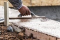 Construction Worker Using Wood Trowel On Wet Cement Forming Coping Around New Pool Royalty Free Stock Photo