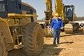 Construction Worker Walking Along Equipment Royalty Free Stock Photo