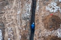 Construction worker walks in trench at the site. Top view