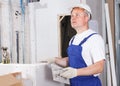 Worker mudding sheetrock wall