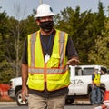 A construction worker wearing full ppe as well as a facemask