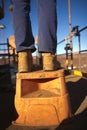 Construction worker wearing heavy duty steel cap boot using safety step white working at height