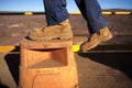 Construction worker wearing heavy duty steel cap boot using safety step white working at height