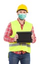 Construction worker wearing protective face mask is presenting shockproof digital tablet