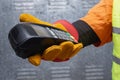 Construction worker wearing protective gloves and reflective workwear holding a wireless payment terminal. Concept of digital Royalty Free Stock Photo
