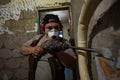Construction worker wearing a respirator and ear protection using a hammer drill for demolition work, removing old plaster and Royalty Free Stock Photo