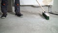 Construction worker sweeping the floor after renovation work. Royalty Free Stock Photo