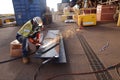 Construction worker wearing safety ears plug helmet, face shield, red welding leather glove protection