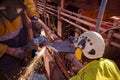 Construction worker wearing side impact rope access safety white helmet attached with yellow noise disruptive earmuffs protection