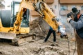 worker welding broken excavator on construction site
