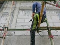 A construction worker working on bamboo scaffolds that are installed around the constructing house - working at height
