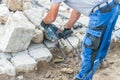 Construction worker is working with granite stones