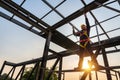 A construction worker working at height equipment using the hook for safety body harness on the roof structure at construction Royalty Free Stock Photo