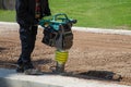 Construction worker working o the road with an earth rammer