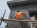 A construction worker is working on plastering a wall