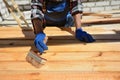 Construction worker is working with wooden beam. The worker brushes the preservative liquid on the folded boards and boards. Royalty Free Stock Photo